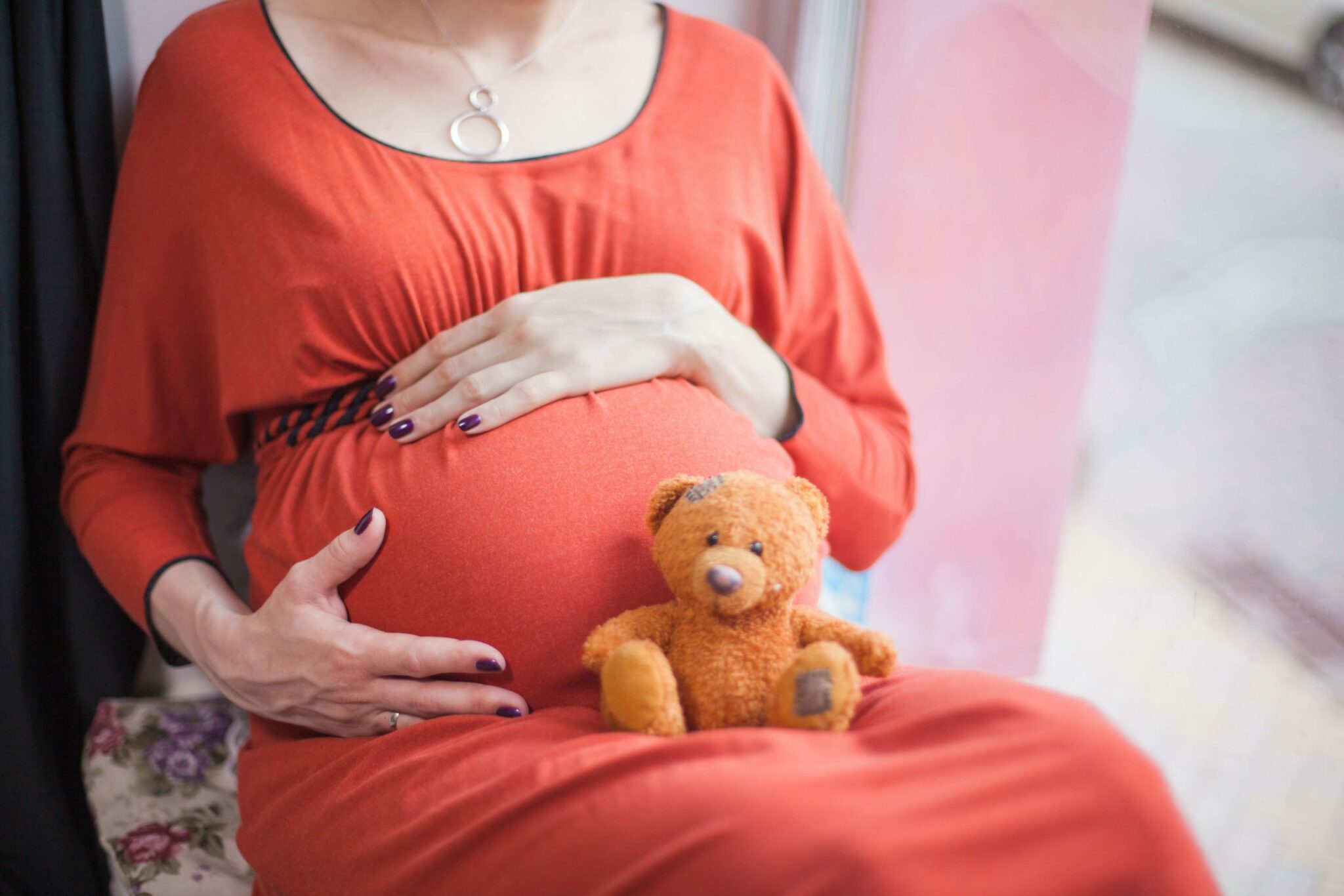 Preganant woman holding a teddy bear