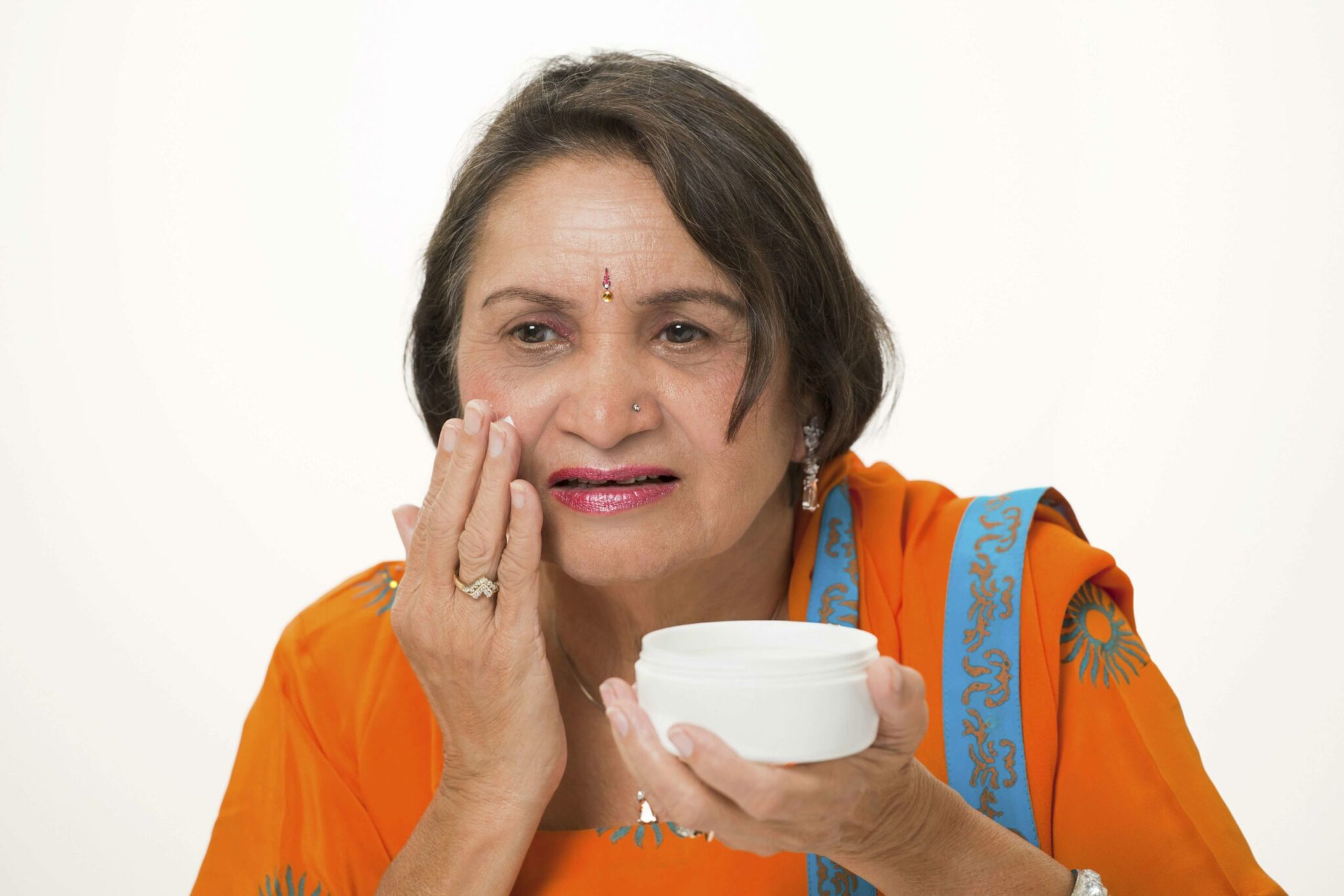 an aged woman applying moisture